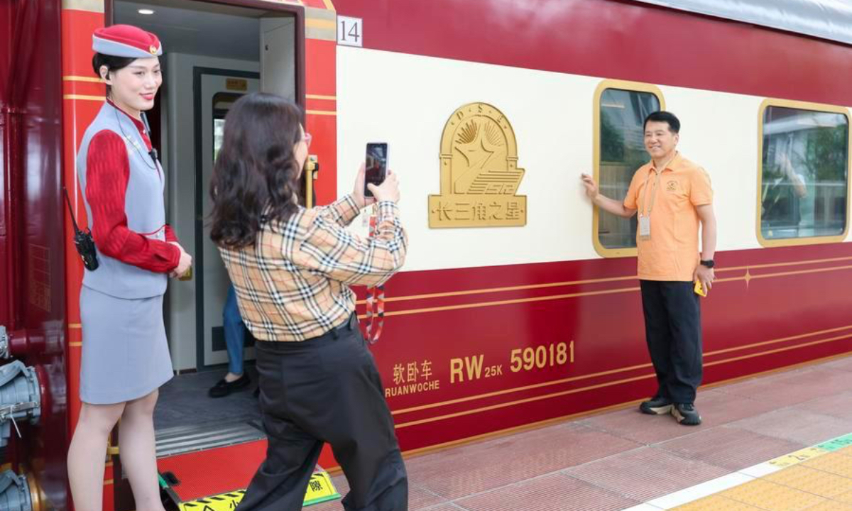A passenger takes a photo before boarding the Delta Star Express in east China's Shanghai, May 19, 2026. (Xinhua/Wang Xiang)