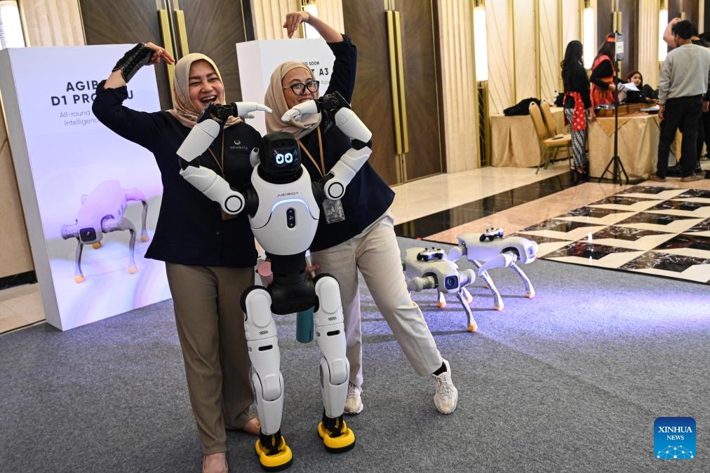Guests interact with a humanoid robot during a partner conference held by Chinese company AGIBOT in Jakarta, Indonesia, June 9, 2026. Chinese embodied AI company AGIBOT on Tuesday held its first partner conference in Indonesia, officially launching its market expansion in the country and showcasing a range of humanoid robots and localized solutions, drawing attention from government officials and industry representatives. (Photo: Xinhua)