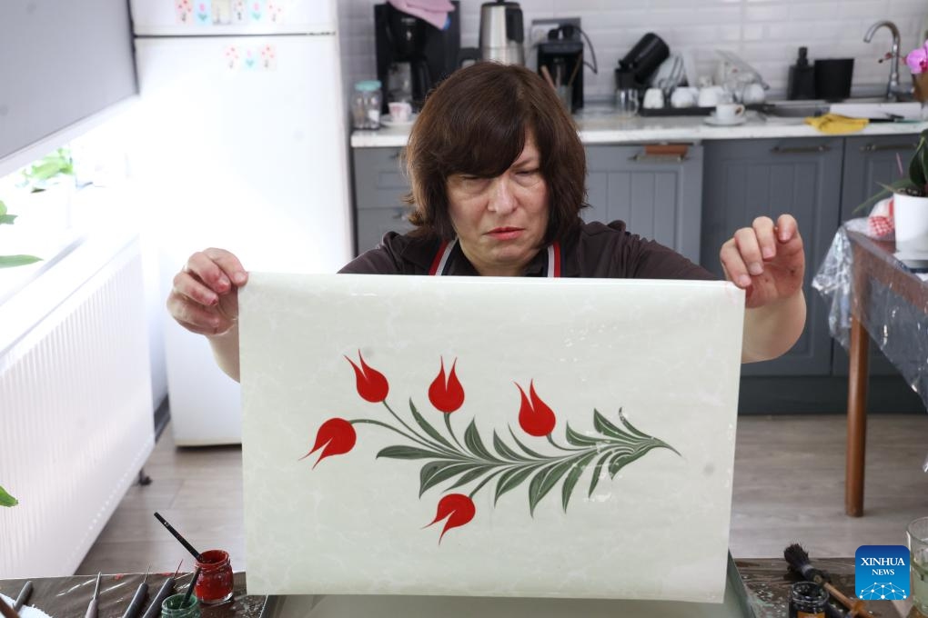 A paper marbling master shows a piece of Ebru she made in Ankara, Türkiye, on June 6, 2026. Believed to have its origins in the Far East and brought to the country through the ancient Silk Road, Ebru, or the Turkish art of paper marbling, has been passed down through generations and is recognized by UNESCO for its cultural significance. (Photo: Xinhua)