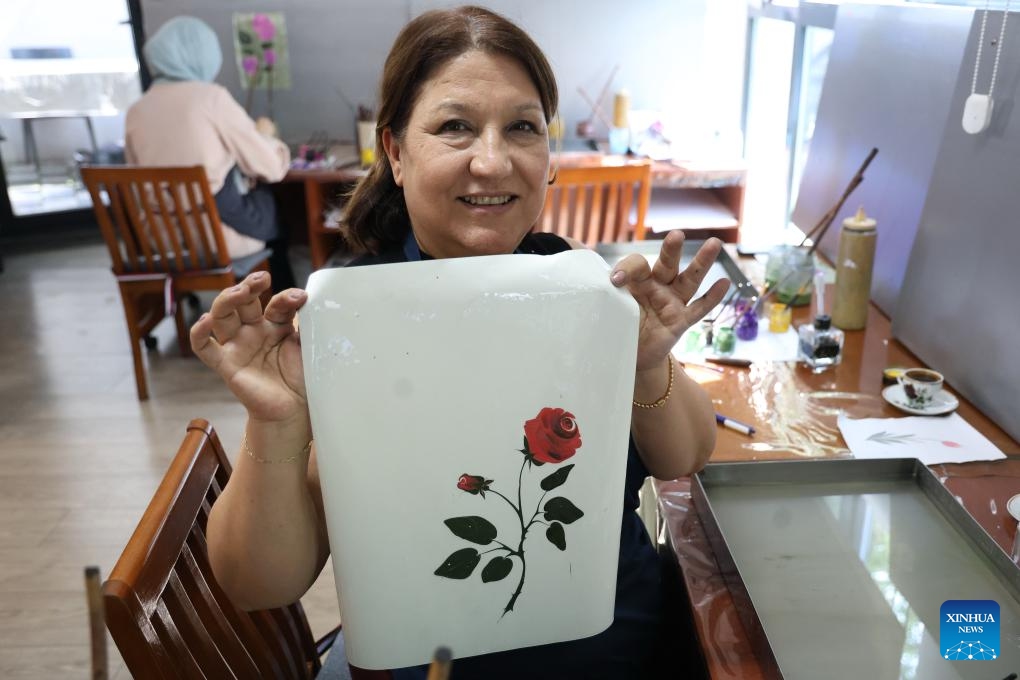 A paper marbling master shows a piece of Ebru she made in Ankara, Türkiye, on June 6, 2026. Believed to have its origins in the Far East and brought to the country through the ancient Silk Road, Ebru, or the Turkish art of paper marbling, has been passed down through generations and is recognized by UNESCO for its cultural significance. (Photo: Xinhua)