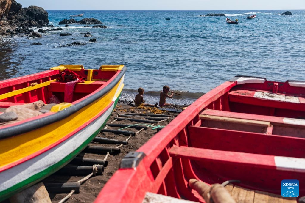 Children play beside painted fishing boats on the seaside of Cidade Velha, Santiago Island, Cabo Verde, May 11, 2026. (Photo: Xinhua)