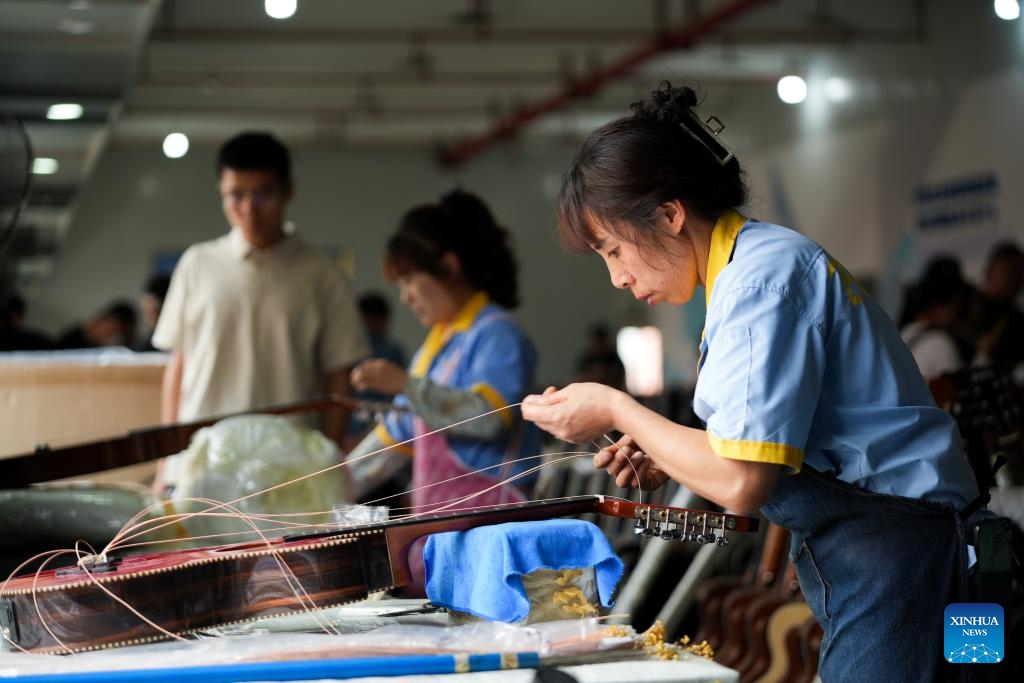 Workers make guitars in the workshop of Zunyi Shenqu Musical Instrument Manufacturing Co., Ltd. in Zheng'an County, Zunyi City, southwest China's Guizhou Province, June 9, 2026. (Photo: Xinhua)