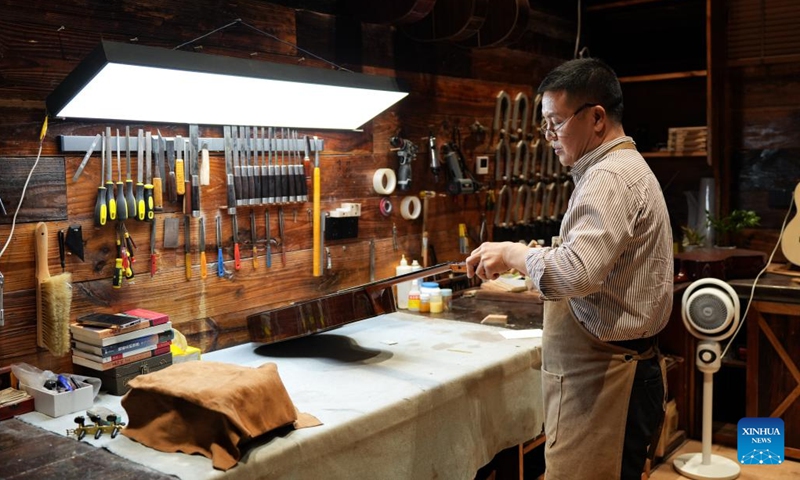 Craftsman Zhang Weiyi works in his studio in the Guitar Culture Industry Park in Zheng'an County, Zunyi City, southwest China's Guizhou Province, June 9, 2026. Zheng'an County has vigorously developed its guitar-making industry in recent years. It is home to 144 guitar and guitar-related accessories manufacturers and has cultivated 87 independent brands. Based on the Guitar Culture Industry Park, a whole industrial chain covering guitar design, production and sales, training and research, and cultural tourism has been established here. (Photo: Xinhua)