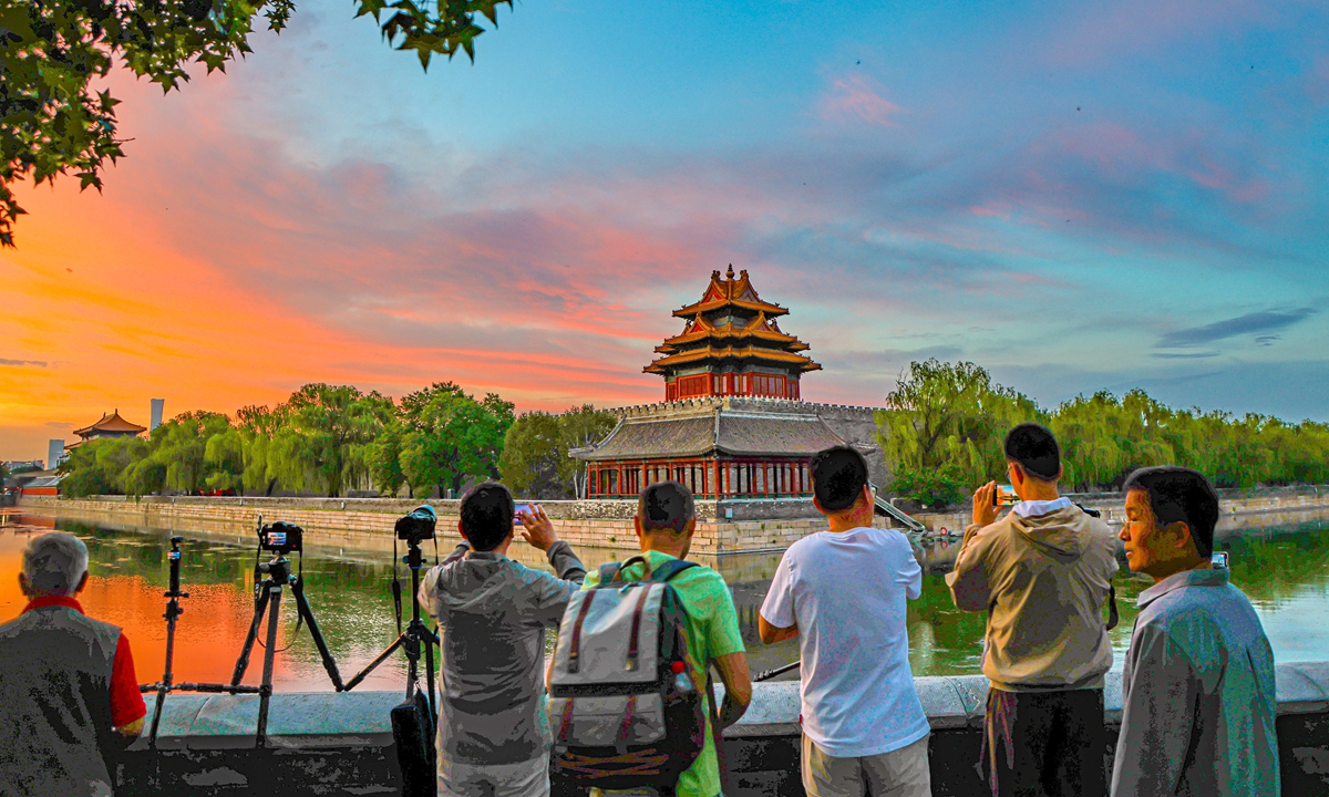 The Forbidden City is bathed in colorful morning glow in Beijing on June 10, 2026. Local residents take pictures of the scene. Photo: IC