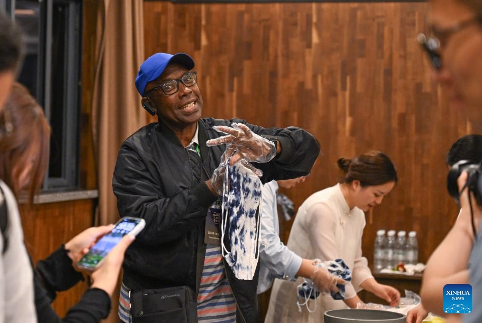 A member of a multinational delegation experiences tie-dye technique in southwest China's Chongqing, June 7, 2026. A group of foreign delegates and experts visited local community, wetland and enterprise in Chongqing, and learned about how China's development has improved people's livelihood. (Photo: Xinhua)