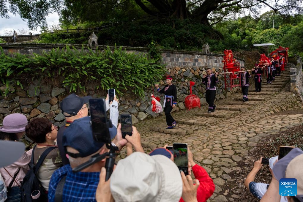 Visitors watch and take pictures of a She-style wedding show in Banyueli Village of Xiapu County, Ningde City, southeast China's Fujian Province, June 10, 2026. She-style wedding custom was inscribed on the national intangible cultural heritage list. (Photo: Xinhua)