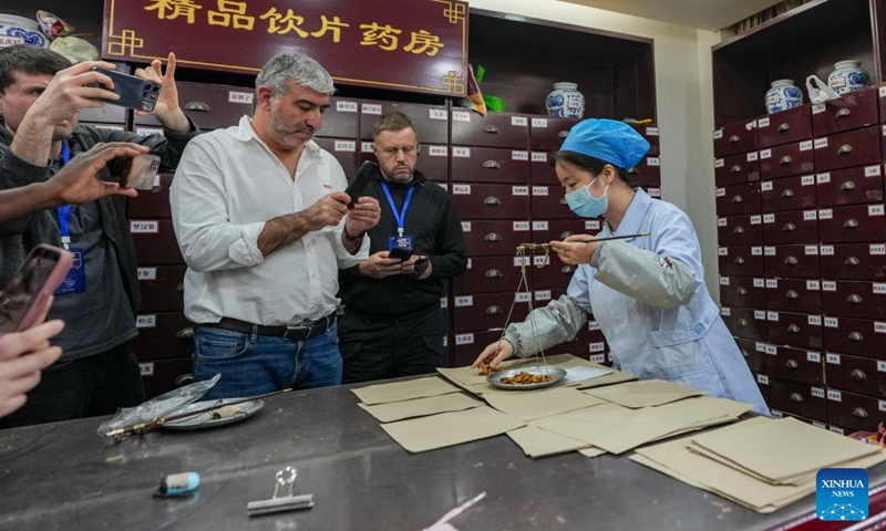 Members of a multinational delegation experience the traditional Chinese medicine at Zaozi Lane in Chengdu, southwest China's Sichuan Province, June 8, 2026. Delegates from 11 countries visited livelihood projects on ecological conservation, cultural and creative industries, and scientific and technological innovation in Sichuan from June 7 to 9. They learned on-site about how China's development has improved people's livelihood. (Photo: Xinhua)