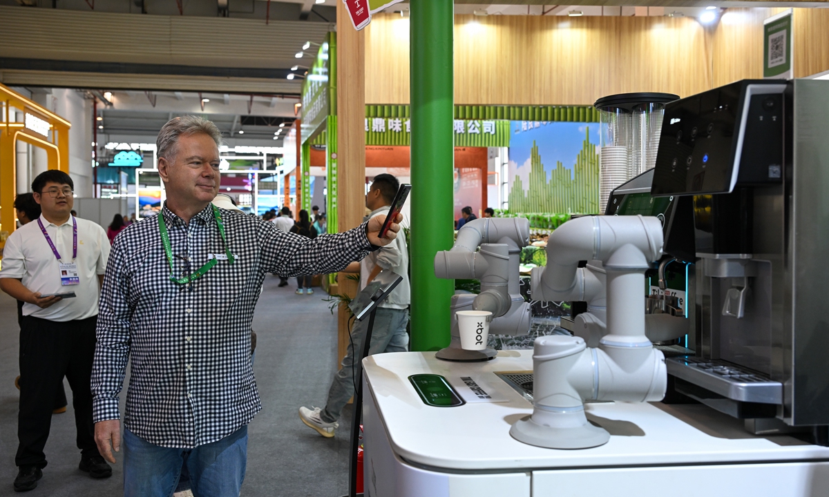A visitor takes photo of a coffee-serving robot during the 10th China-South Asia Expo that kicked off in Kunming, capital of Southwest China's Yunnan Province on June 11, 2026. Putting an emphasis on enhancing regional trade and industrial cooperation under the theme