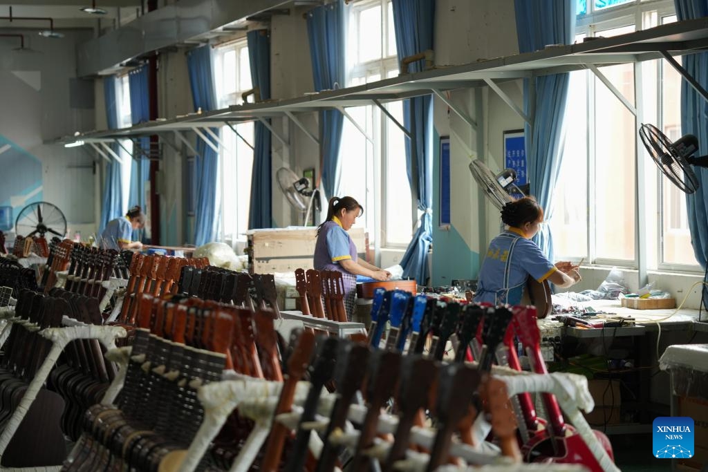 Workers make guitars in the workshop of Zunyi Shenqu Musical Instrument Manufacturing Co., Ltd. in Zheng'an County, Zunyi City, southwest China's Guizhou Province, June 9, 2026. (Photo: Xinhua)