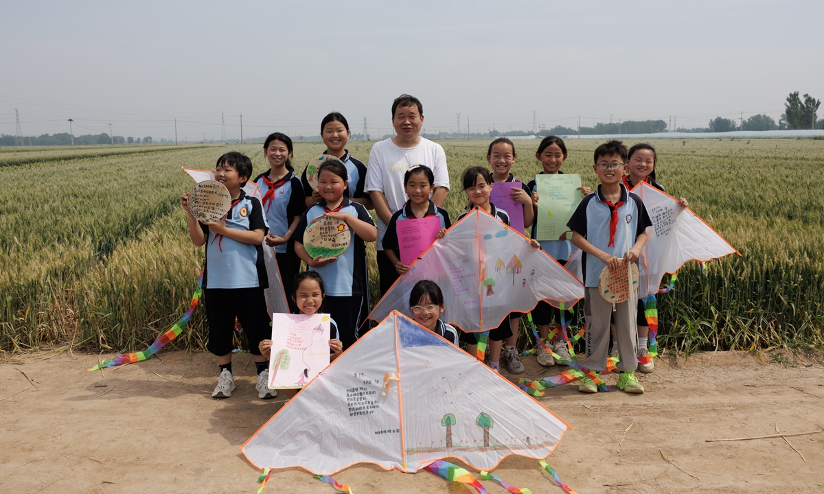 Yang Zhanguo (center) poses for a photo with his students in Yingtaoyuan township in Liaocheng, Shandong Province. Photo: Courtesy of Yang Zhanguo 