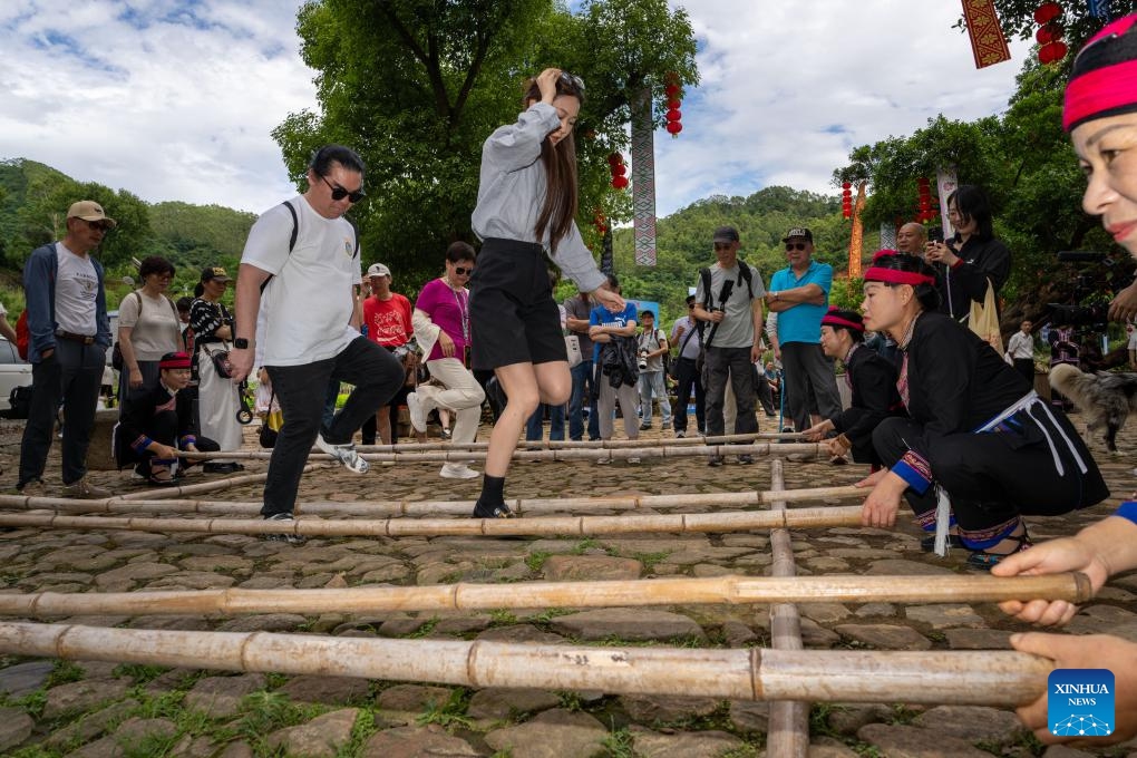 Visitors try a bamboo-stick dance in Banyueli Village of Xiapu County, Ningde City, southeast China's Fujian Province, June 10, 2026. (Photo: Xinhua)
