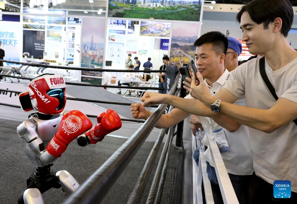 Visitors interact with a robot during the 12th China (Shanghai) International Technology Fair (CSITF) in east China's Shanghai, June 11, 2026. The 12th China (Shanghai) International Technology Fair, scheduled from June 11 to 13, kicked off at the Shanghai World Expo Exhibition and Convention Center on Thursday. The fair covers an exhibition area of about 38,000 square meters, showcasing innovative technological achievements in fields including artificial intelligence, green fuels, energy storage and transportation, smart home application and elderly care. (Xinhua/Fang Zhe)