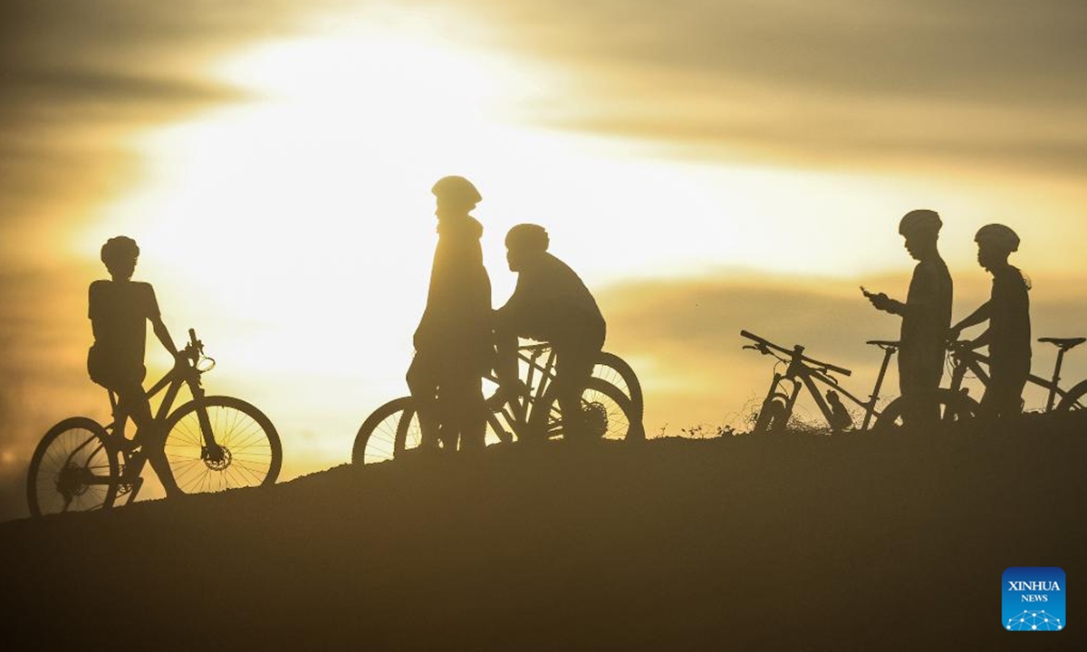 Cyclists enjoy the view of sunset in Ilocos Sur Province, the Philippines, on June 11, 2026. (Xinhua/Rouelle Umali)