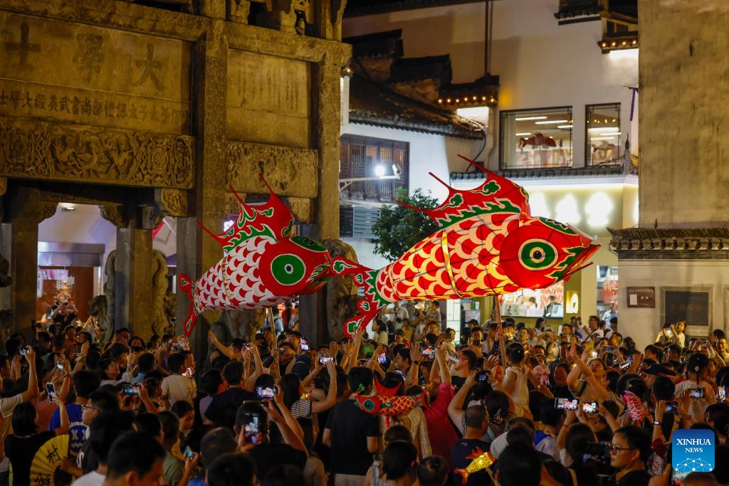 Tourists watch a fish-shaped lantern parade at Huizhou Ancient City in Huangshan, east China's Anhui Province, Oct. 2, 2025. (Photo by Shi Yalei/Xinhua)
