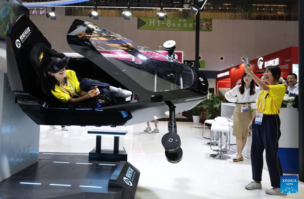 A visitor plays an air combat game in a manned flight simulation module during the 12th China (Shanghai) International Technology Fair (CSITF) in east China's Shanghai, June 11, 2026. The 12th China (Shanghai) International Technology Fair, scheduled from June 11 to 13, kicked off at the Shanghai World Expo Exhibition and Convention Center on Thursday. The fair covers an exhibition area of about 38,000 square meters, showcasing innovative technological achievements in fields including artificial intelligence, green fuels, energy storage and transportation, smart home application and elderly care. (Xinhua/Fang Zhe)