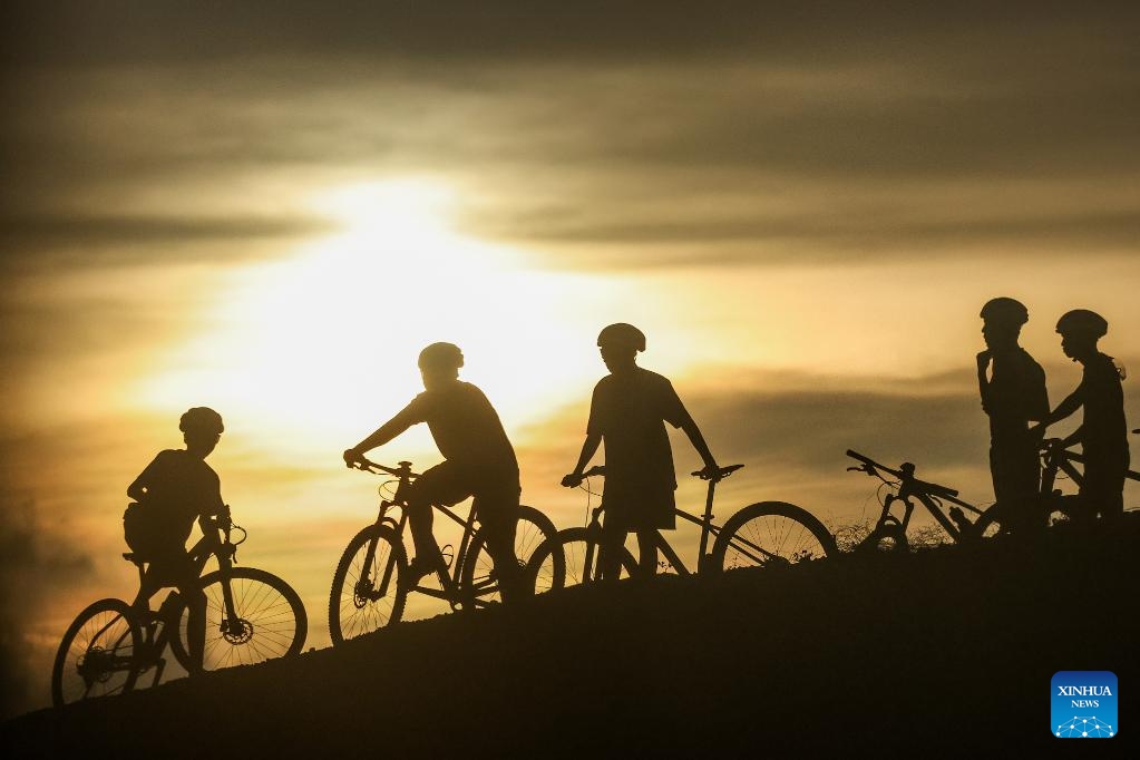 Cyclists enjoy the view of sunset in Ilocos Sur Province, the Philippines, on June 11, 2026. (Xinhua/Rouelle Umali)