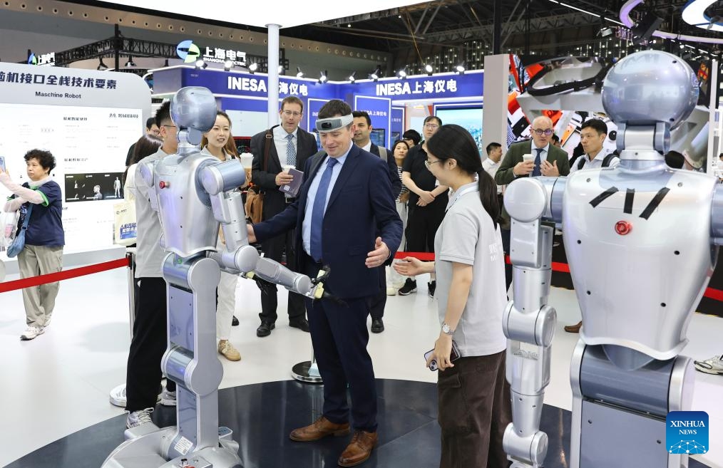 A visitor tries to control a robot with a wearable brain-computer interface (BCI) device during the 12th China (Shanghai) International Technology Fair (CSITF) in east China's Shanghai, June 11, 2026. The 12th China (Shanghai) International Technology Fair, scheduled from June 11 to 13, kicked off at the Shanghai World Expo Exhibition and Convention Center on Thursday. The fair covers an exhibition area of about 38,000 square meters, showcasing innovative technological achievements in fields including artificial intelligence, green fuels, energy storage and transportation, smart home application and elderly care. (Xinhua/Fang Zhe)
