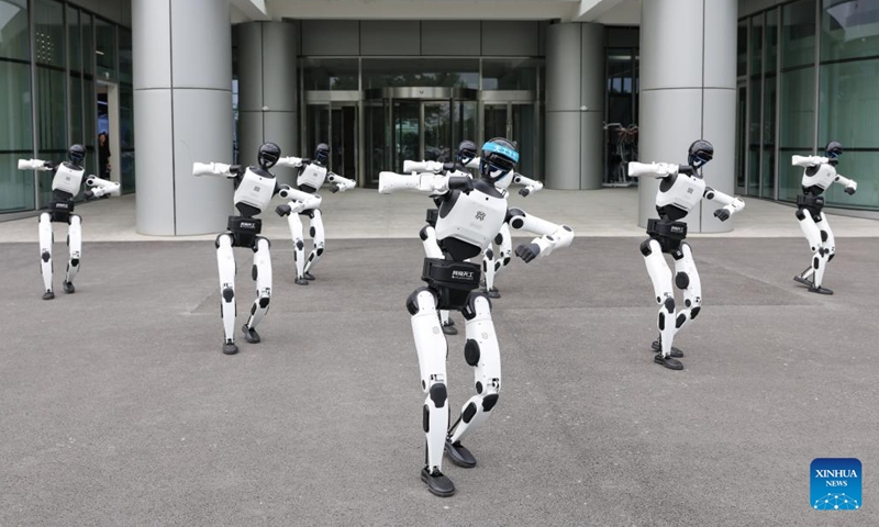 Humanoid robots welcome visitors with a dance outside the embodied intelligence robot data and training base of the Beijing Innovation Center of Humanoid Robotics in Beijing, capital of China, June 12, 2026.

