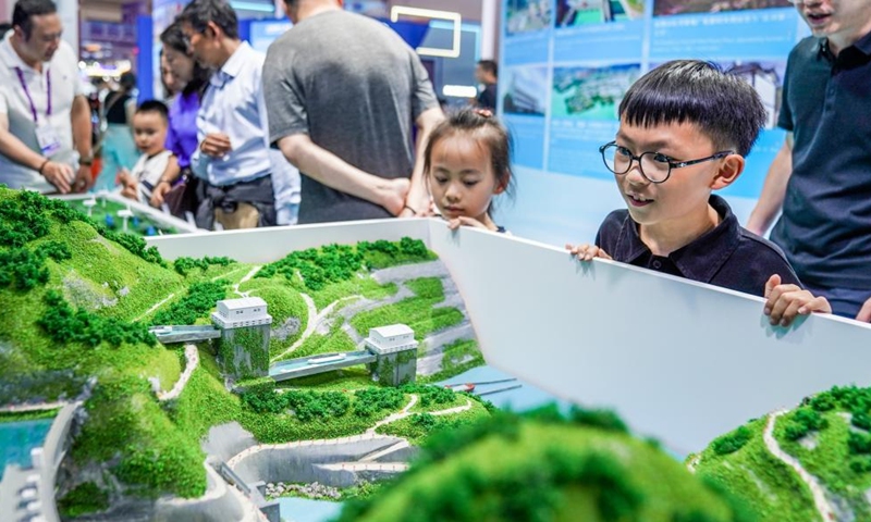 Children look at the Goupitan hydropower station sand table at the Green Energy Pavilion during the 10th China-South Asia Expo in Kunming, southwest China's Yunnan Province, June 13, 2026. (Xinhua/Peng Yikai)