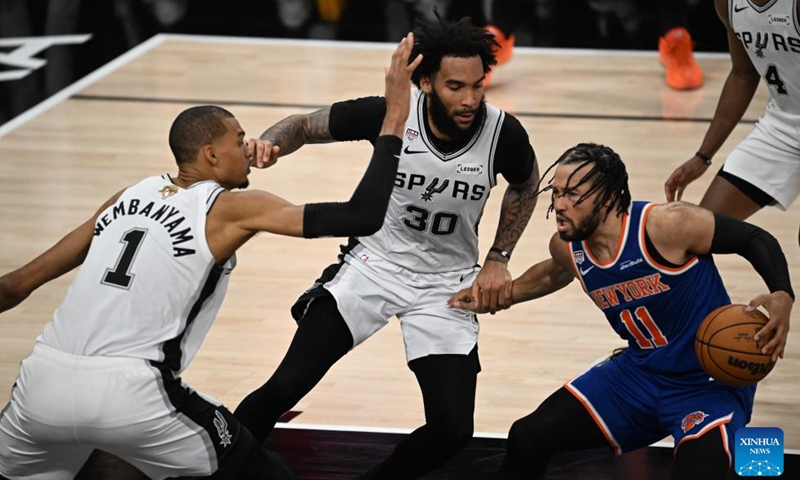 Victor Wembanyama (L) and Julian Champagnie(C) of San Antonio Spurs defend Jalen Brunson of New York Knicks during the final game 5 between New York Knicks and San Antonio Spurs at the 2025-2026 NBA basketball game in San Antonio, the United States, June 13, 2026. (Xinhua/Wu Xiaoling)