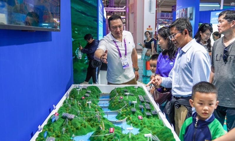 A staff member introduces to visitors the distribution of hydropower stations in the upper reaches of the Jinsha River via a sand table at the Green Energy Pavilion during the 10th China-South Asia Expo in Kunming, southwest China's Yunnan Province, June 13, 2026. (Xinhua/Peng Yikai)