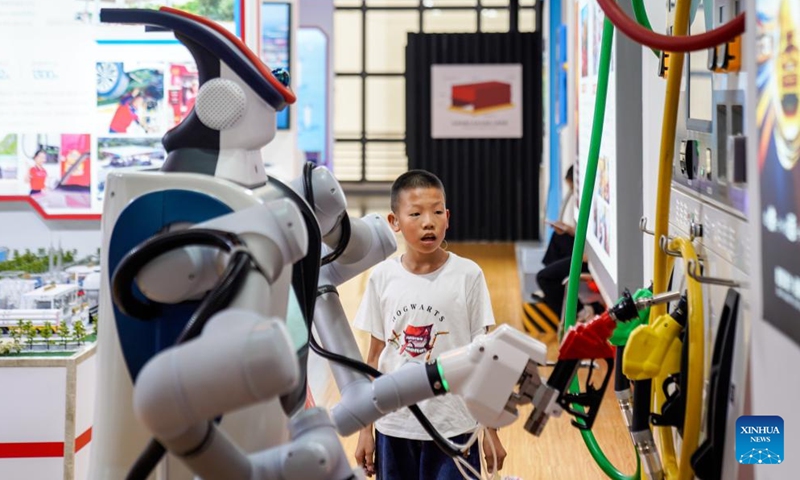 A boy watches an intelligent refueling robot demonstrating its working process at the Green Energy Pavilion during the 10th China-South Asia Expo in Kunming, southwest China's Yunnan Province, June 13, 2026. (Xinhua/Peng Yikai)