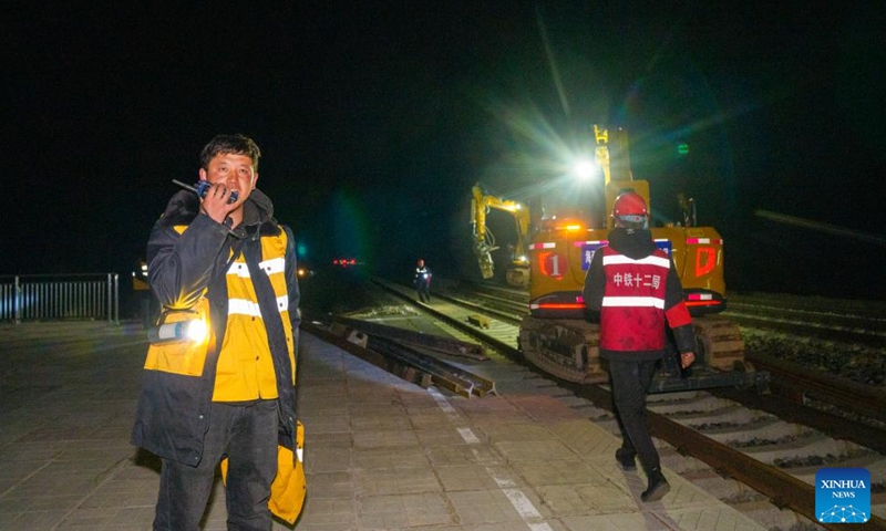 A worker communicates at the site of a rail replacement project on the Golmud-Lhasa section of the Qinghai-Xizang Railway at Amdo South Station in Amdo County of Nagqu, southwest China's Xizang Autonomous Region, June 13, 2026. Braving an altitude of over 4,000 meters, workers from the railway maintenance company of China Railway 12th Bureau Group Co., Ltd. have recently replaced the old rails with the seamless tracks on the Golmud-Lhasa section of the Qinghai-Xizang Railway. All jobs were done during night-time idle period without train traffic at Amdo South Station in Amdo County of Xizang. (Xinhua/Tenzin Nyida)
