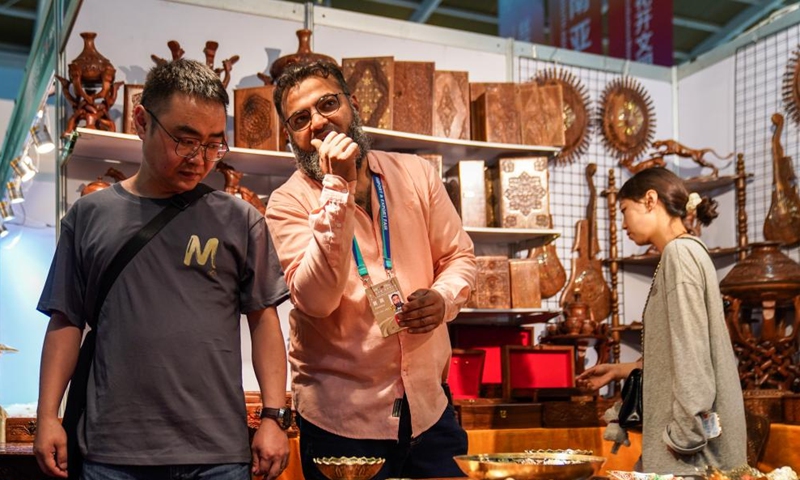 Saad (C) communicates with a visitor at the 10th China-South Asia Expo in Kunming, southwest China's Yunnan Province, June 13, 2026. Photo: Xinhua
