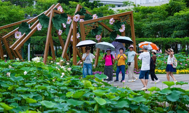 Tourists pose for photos with lotus flowers at the Taipa Houses Museum in Macao, south China, June 15, 2026. The 26th Macao Lotus Flower Festival is held here from June 12 to July 17. (Xinhua/Cheong Kam Ka)