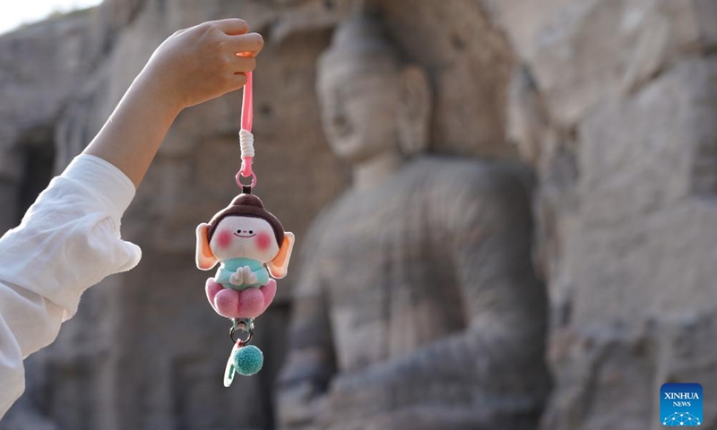 A tourist takes photos with a cultural product at Yungang Grottoes in Datong City, north China's Shanxi Province, May 20, 2026.Photo: Xinhua