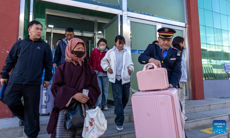 A staff member helps a passenger carry luggage at the Nagqu Railway Station in Nagqu, southwest China's Xizang Autonomous Region, June 14, 2026. With an altitude of 4,513 meters, the Nagqu Railway Station was put into operation in 2006, when the Qinghai-Xizang Railway became operational. Over the past 20 years, the station has handled a total of 8.9471 million passenger trips, and has continuously optimized its services to ensure smooth travel for passengers. (Photo: Xinhua)