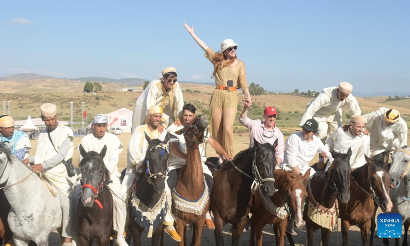 Tourists and riders pose for a photo during the 14th edition of the MATA International Equestrian Festival in Larache, Morocco, June 14, 2026. (Photo: Xinhua)