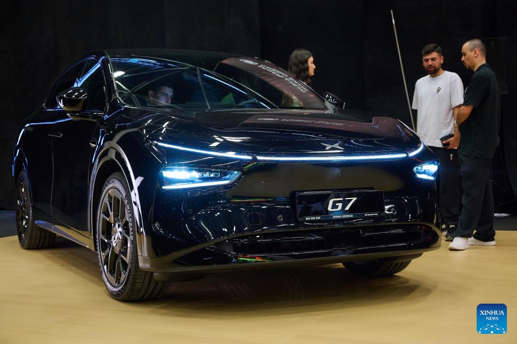 Visitors view an Xpeng G7 at Expo Georgia in Tbilisi, Georgia, June 13, 2026. This year's expo was held here from Saturday to Sunday. Chinese automakers including BYD, XPeng, AVATR and JAC Motors have made appearances with their products at the expo. (Photo: Xinhua)