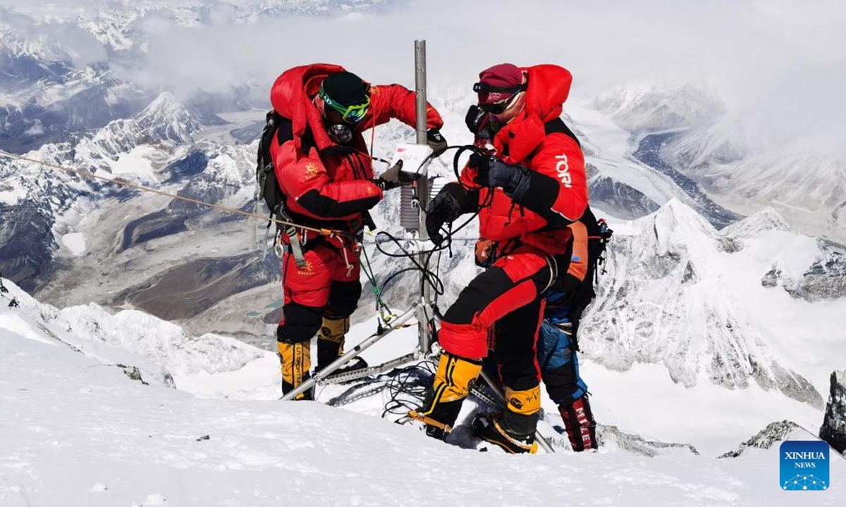This photo taken on May 4, 2022 shows researchers setting an automatic weather station at an altitude of 8,830 meters on Mount Qomolangma. (Xinhua/Sonam Dorje)