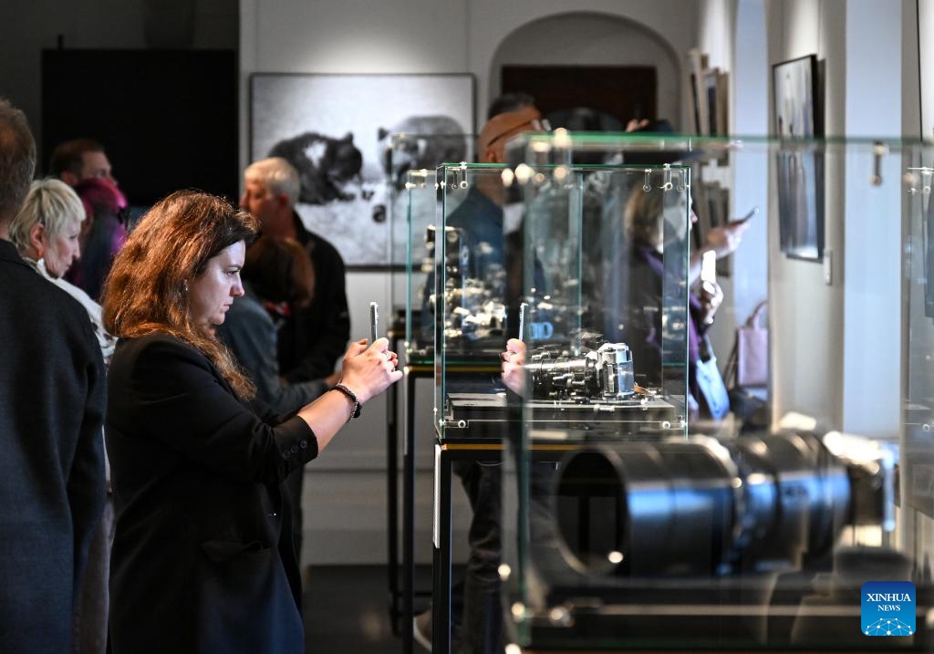 A woman photographs the vintage cameras showcased at the TASS Photo Chronicle Centennial Exhibition at the State Historical Museum in Moscow, capital of Russia, June 16, 2026. On June 16, the TASS Photo Chronicle Centennial Exhibition opened at the State Historical Museum in Moscow, capital of Russia. The exhibition features numerous photographs captured by TASS, marking the 100th anniversary of the founding of its photo chronicle department. The exhibition will run until August 31. (Xinhua/Feng Kaihua)