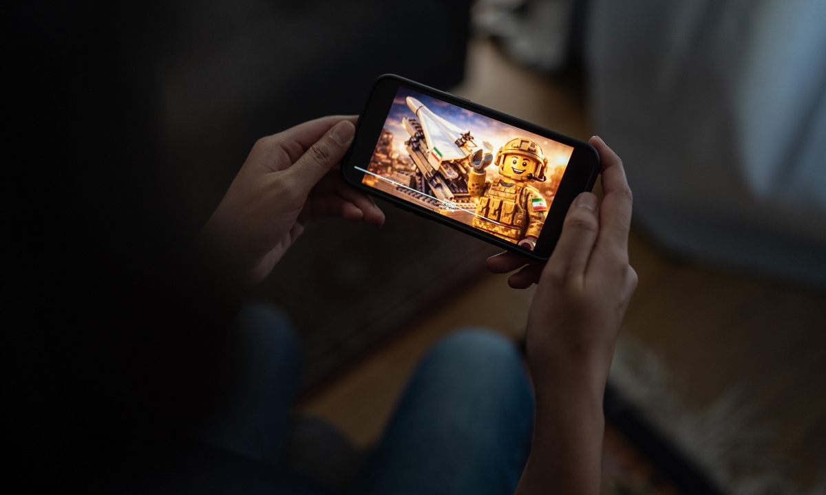 A person watches a Lego-style video about the US-Israeli strikes on Iran. Photo: VCG
