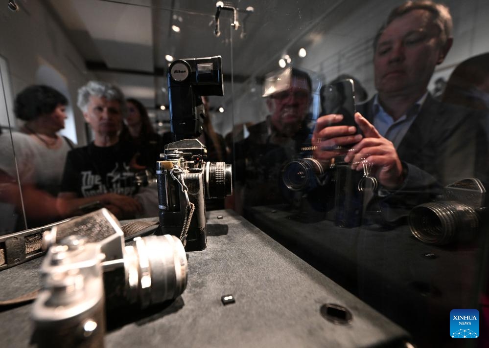 Visitors watch and photograph the vintage cameras on display at the TASS Photo Chronicle Centennial Exhibition at the State Historical Museum in Moscow, capital of Russia, June 16, 2026. On June 16, the TASS Photo Chronicle Centennial Exhibition opened at the State Historical Museum in Moscow, capital of Russia. The exhibition features numerous photographs captured by TASS, marking the 100th anniversary of the founding of its photo chronicle department. The exhibition will run until August 31. (Xinhua/Feng Kaihua)
