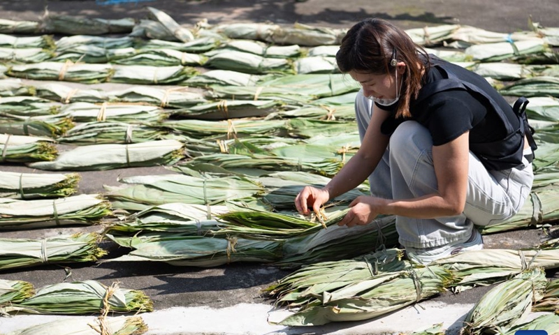 Zheng Hui, a young entrepreneur, dries bamboo leaves at Shiren Village of Xiuning County, Huangshan City of east China's Anhui Province, June 15, 2026. Shiren Village, dubbed the hometown of zongzi (sticky rice dumplings) in ancient Huizhou, boasts a long tradition of zongzi making. The annual sales of zongzi in the village has reached 900,000 yuan (about 133,000 U.S. dollars). (Xinhua/Zhang Duan)