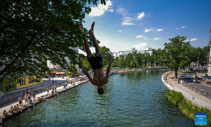 A man jumps into the Saint-Martin Canal to cool off during hot weather in Paris, France, June 18, 2026. (Photo: Xinhua)