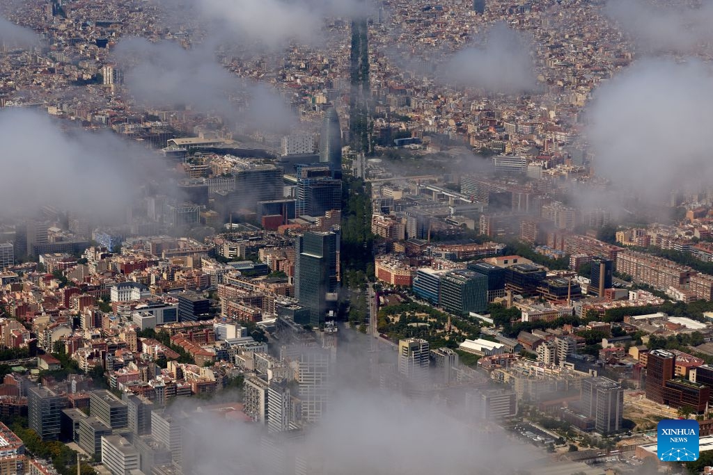 An aerial photo taken on June 18, 2026 shows the cityscape of Barcelona, Spain. Barcelona displays its distinctive grid layout, with the Sagrada Familia Basilica rising prominently among the city blocks. Designed by urban planner Ildefons Cerda in the 19th century, the grid structure continues to shape the development and identity of the Mediterranean city. (Photo: Xinhua)