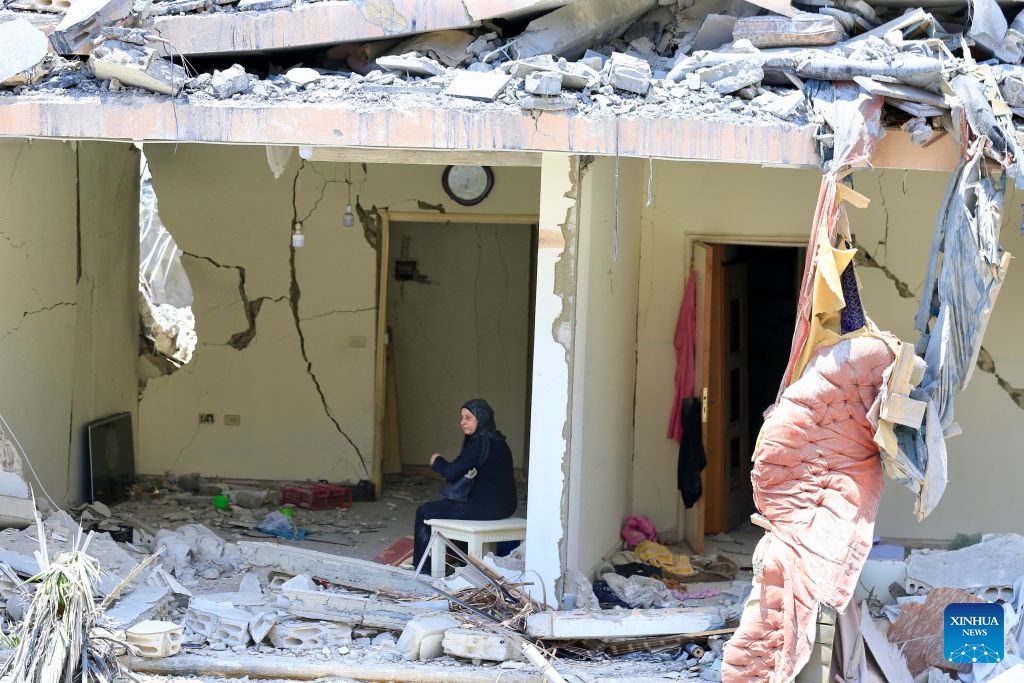 Photo taken on June 18, 2026 shows a woman sitting in a destroyed building after Israeli attacks in Nabatieh, southern Lebanon. (Photo: Xinhua)