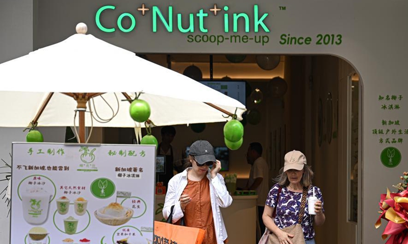 Customers leave a store of Singaporean dessert brand Co+Nut+Ink at the Qilou Old Street in Haikou, south China's Hainan Province, June 19, 2026. (Xinhua/Pu Xiaoxu)