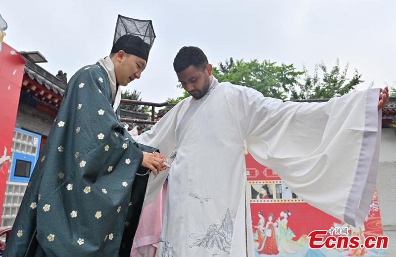 A foreign student (right) tries on hanfu, traditional Chinese clothing, at the Confucius Temple in Changchun, Jilin province, on June 16, 2026. Photo: China News Service