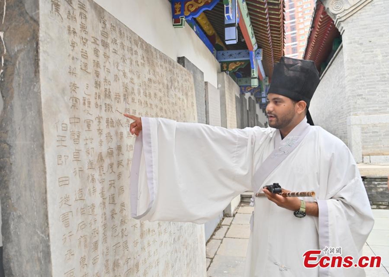 A foreign student dressed in hanfu reads inscriptions on stone tablets at the Confucius Temple in Changchun, Jilin province, on June 16, 2026. Photo: China News Service