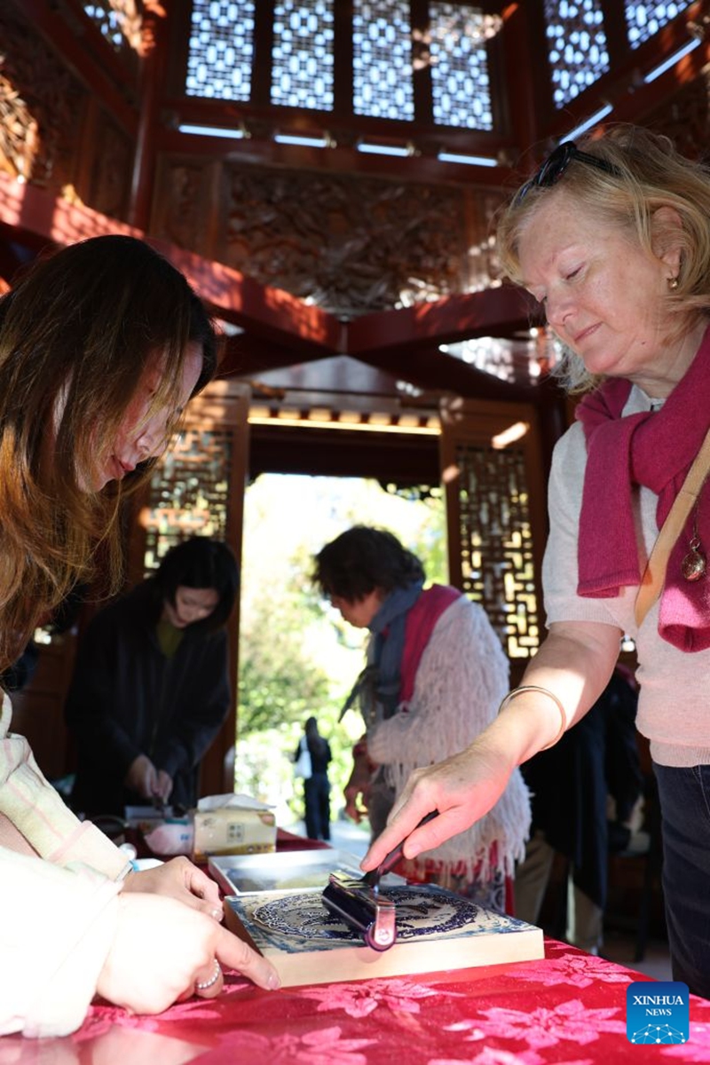 A visitor tries Yangliuqing woodblock painting during a fair called Tea for Harmony and Dragon Boat Festival Cultural Fair in Sydney held at a park in Sydney, Australia, June 20, 2026. Photo: Xinhua