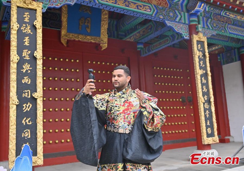 A foreign student dressed in hanfu shoots short videos at the Confucius Temple in Changchun, Jilin province, on June 16, 2026. Photo: China News Service