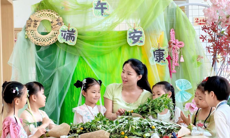 A teacher guides children to make mugwort bundles at a kindergarten in Jiyuan City, central China's Henan Province, June 17, 2026. Various activities have been held across China to welcome the upcoming Duanwu Festival, or Dragon Boat Festival, which falls on June 19 this year. (Photo by Duan Erping/Xinhua)