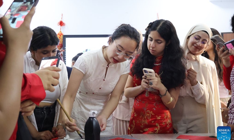 A Chinese teacher (2nd L) demonstrates calligraphy at the Confucius Institute at Carthage University in Tunis, Tunisia, on June 19, 2026. The Confucius Institute at the Carthage University held on Friday a Dragon Boat Festival cultural event, attracting many people to experience the unique charm of Chinese traditional culture. (Xinhua/Zhou Haojin)