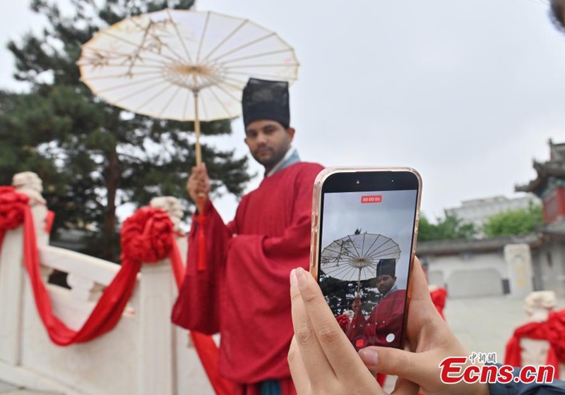 A foreign student dressed in hanfu shoots short videos at the Confucius Temple in Changchun, Jilin province, on June 16, 2026. Photo: China News Service