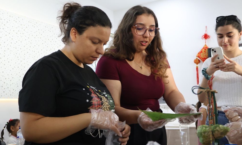 People make Zongzi (sticky rice dumplings) at the Confucius Institute at Carthage University in Tunis, Tunisia, on June 19, 2026. The Confucius Institute at the Carthage University held on Friday a Dragon Boat Festival cultural event, attracting many people to experience the unique charm of Chinese traditional culture. (Xinhua/Zhou Haojin)
